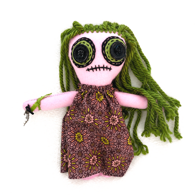 Handmade Hoodoo doll with green hair and floral dress on a white background