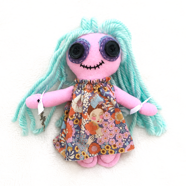 Hoodoo Healing doll with teal hair and a colorful dress on a white background