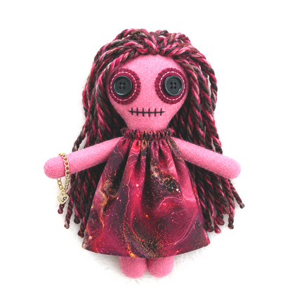 Pink hoodoo doll with red hair and black eyes on a white background