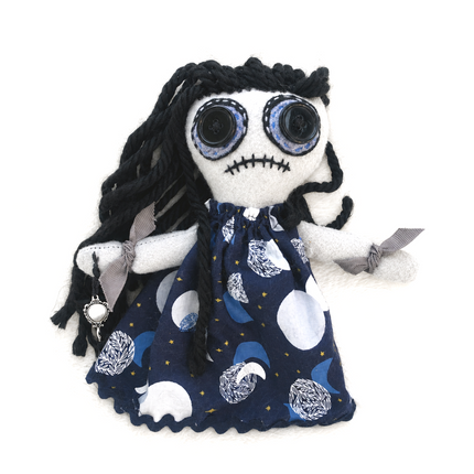 return-to-sender hoodoo doll with black hair and a blue dress with moon patterns on a white background