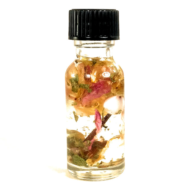 A small clear bottle with a black cap containing almond oil, essential oils, pink rose petals, a clear pink glass bead, a hawthorn thorn and various botanicals formulated for BDSM submission intentions.